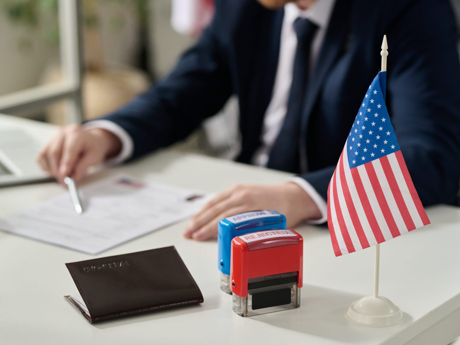 Close up of approved and rejected stamps on table in US immigration office with flag, copy space